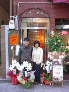 開店時、夫婦二人と贈られた多くの花々との写真